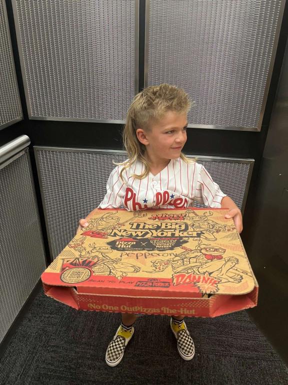 Rory in the elevator with a pizza.