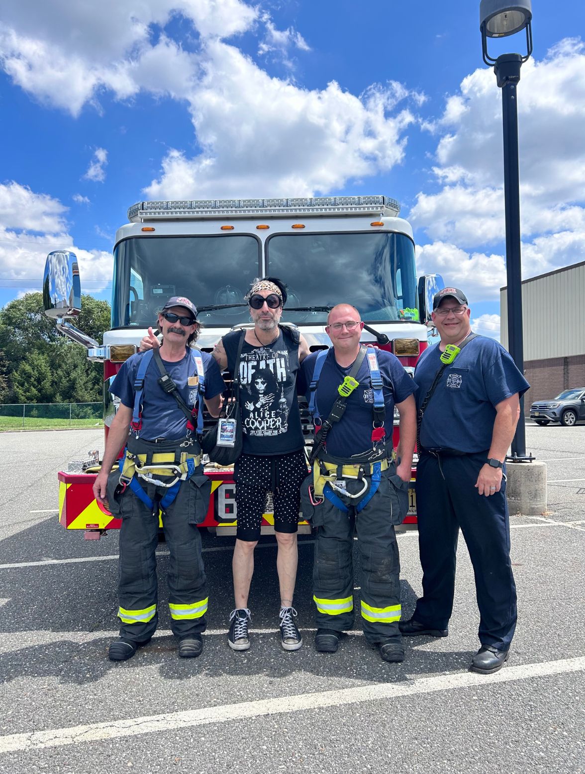 Jacky BamBam standing with three Voorhees fire department firefighters next to their firetruck