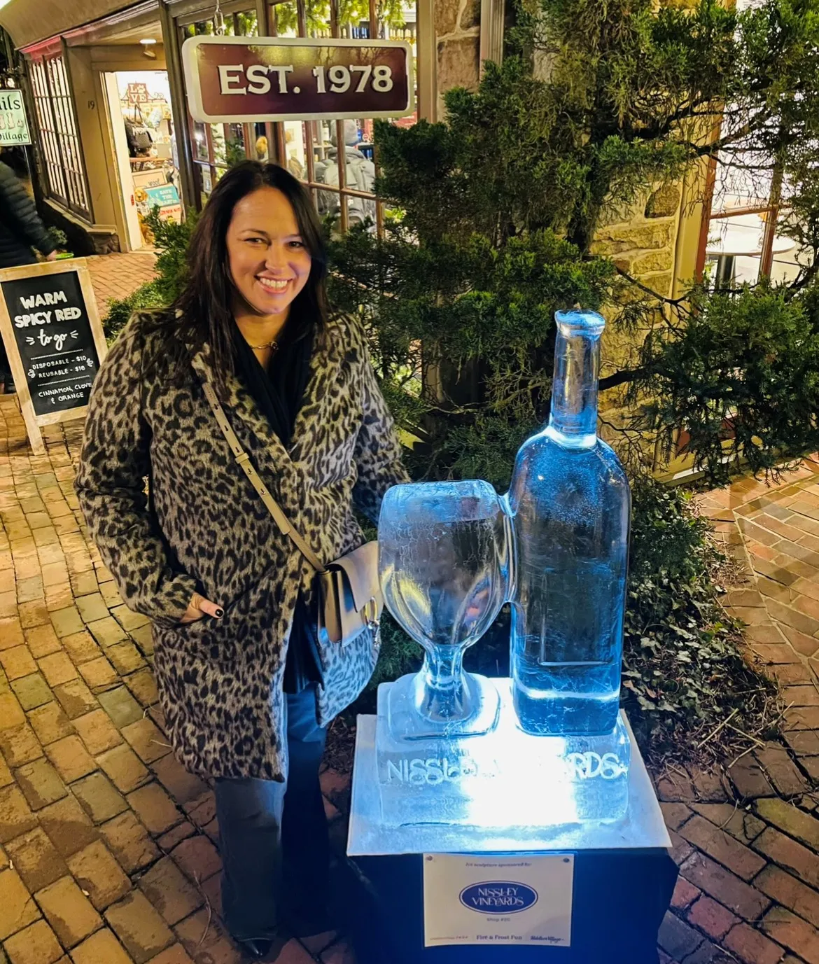 Kathy next to bottle and wine glass ice sculpture