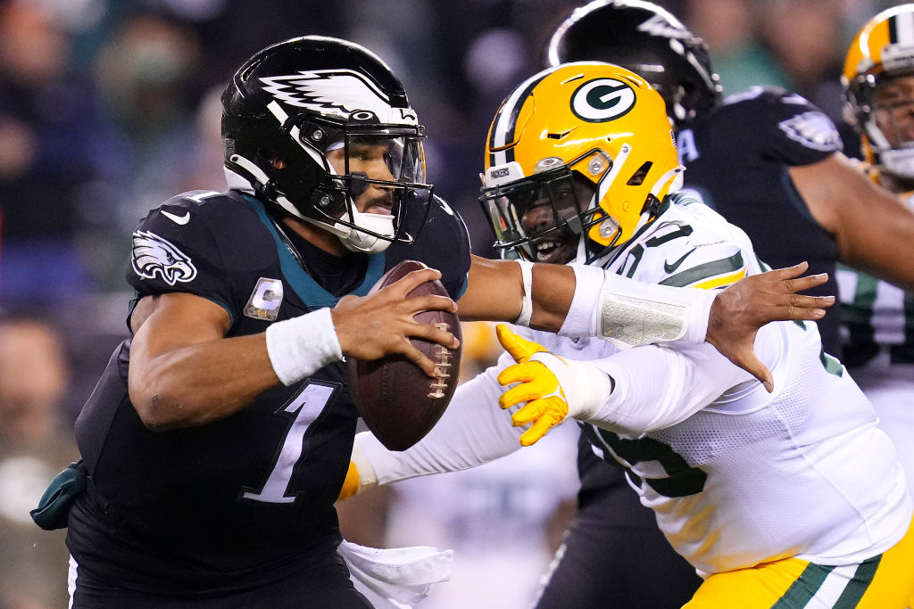 Jalen Hurts #1 of the Philadelphia Eagles avoids pressure from Devonte Wyatt #95 of the Green Bay Packers during the third quarter at Lincoln Financial Field on November 27, 2022 in Philadelphia, Pennsylvania.